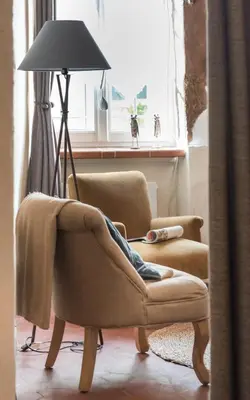 a living room with two chairs and a lamp at Su Lei Campanes in Lauris