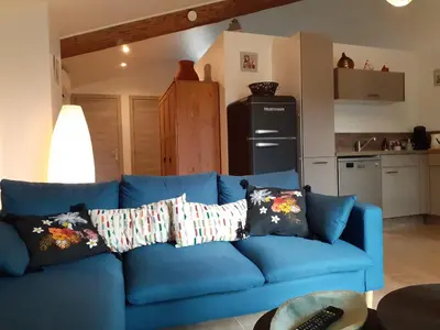 a blue couch with pillows in a living room at L'ARCHIMBAUDE in Pertuis