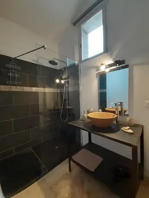 a bathroom with a sink and a glass shower at L'ARCHIMBAUDE in Pertuis
