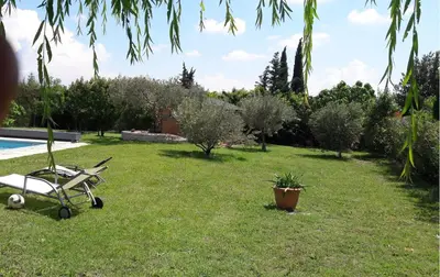a yard with a chair and a swimming pool at Villa Eglantine in Caumont-sur-Durance