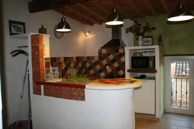 a kitchen with a counter top in a kitchen with a stove at Gîte Mas de la Restanque in Monteux