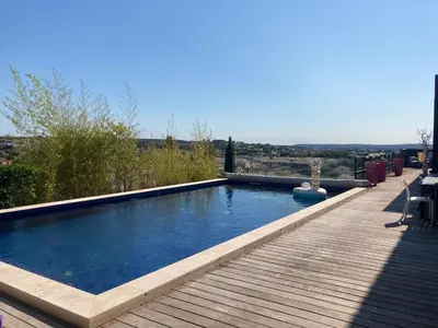 a large swimming pool with a wooden walkway next to it at Belle villa en Provence in Lançon-Provence