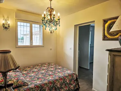 a bedroom with a bed and a chandelier at Villa Les Angevines by Interhome in Morières-lès-Avignon