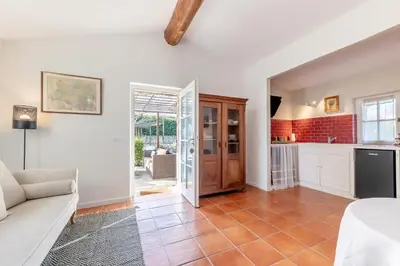 a living room with a couch and a kitchen at Mas Oréa côté piscine in Gordes