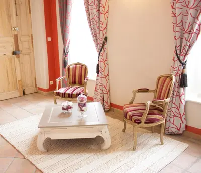 a living room with two chairs and a coffee table at Gite des Carmes and Spa in Le Thor