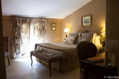 a bedroom with a bed and a table and a window at Domaine de Mejeans - Teritoria in Alleins