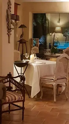 a table with a candle and two chairs in a room at Domaine de Mejeans - Teritoria in Alleins