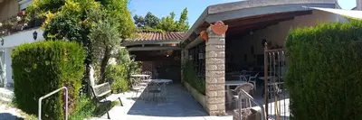 a house with a patio with a table and chairs at Hotel Font De Lauro in Saumane-de-Vaucluse