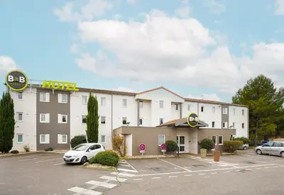 a hotel with cars parked in a parking lot at B&B HOTEL Aix-en-Provence Pont de l'Arc in Aix-en-Provence