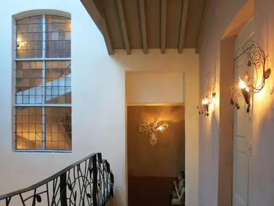 a hallway of a house with a staircase and a window at La Maison Sur La Sorgue - Esprit de France in LʼIsle-sur-la-Sorgue