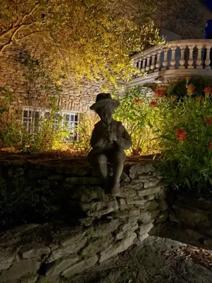 a statue of a woman sitting on a wall at Le Jas des Parpaillous in LʼIsle-sur-la-Sorgue