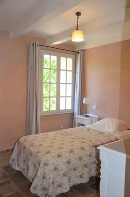 a bedroom with a large bed and a window at Le Jas des Parpaillous in LʼIsle-sur-la-Sorgue