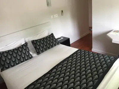 a bedroom with a large bed with black and white sheets at Hôtel Vendôme in Aix-en-Provence