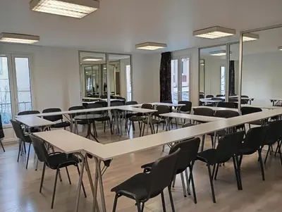 a room with tables and chairs and windows at Adonis Arc Hotel Aix in Aix-en-Provence