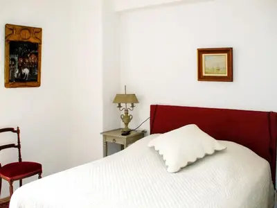 a white bed with a red headboard and a red chair at Maison de charme à Mollégès avec piscine privée in Mollégès