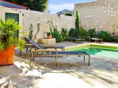 a pool with two chairs and a bench next to a house at Maison de charme à Mollégès avec piscine privée in Mollégès