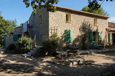 an old brick house with green shutters on it at Mas Val-Chênaie Gordes in Gordes