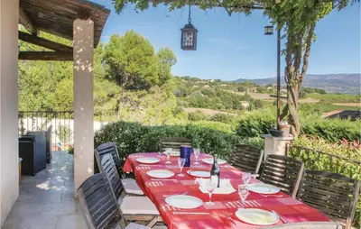 a table with plates and wine glasses on a patio at 4 Bedroom Beautiful Home In Goult in Goult
