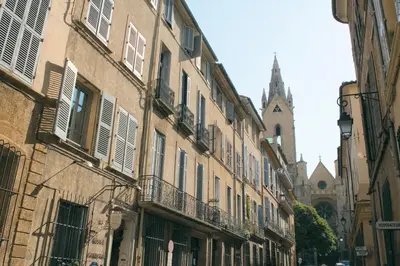an alley with buildings and a church in the background at Hotel Cardinal in Aix-en-Provence