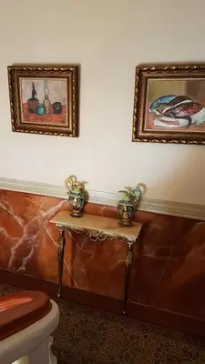 a bathroom with a toilet and two pictures on the wall at Hotel Cardinal in Aix-en-Provence