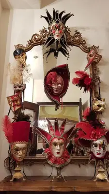 a mirror with a group of masks on a table at Hotel Cardinal in Aix-en-Provence