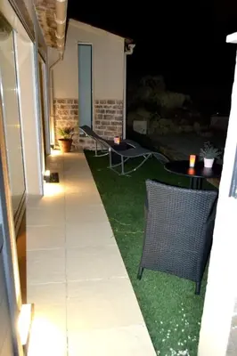 a patio with two chairs and a table on the grass at L instant Magique in Beaumont-de-Pertuis