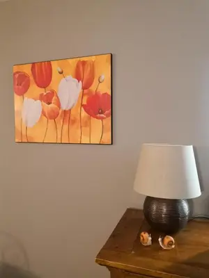a lamp on a table with a painting on the wall at Bastidon Provencal in Gordes