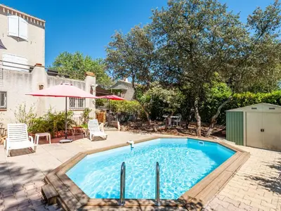 a pool in a yard with chairs and an umbrella at Apartment Mireio by Interhome in Lambesc