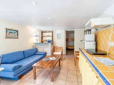 a living room with a blue couch and a kitchen at Apartment Mireio by Interhome in Lambesc