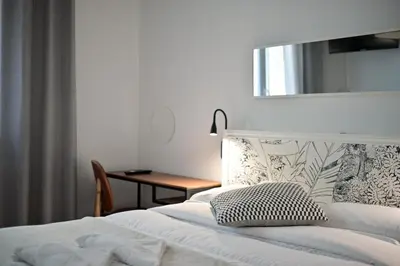 a bedroom with a bed with a mirror and a table at Hôtel Paul in Aix-en-Provence