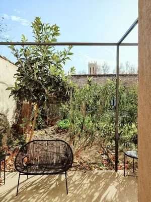 a bench sitting on a patio with a garden at Hôtel Paul in Aix-en-Provence