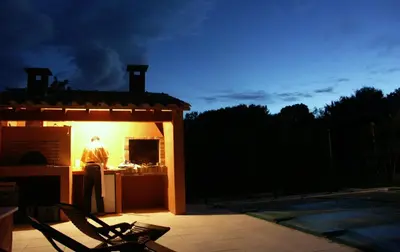 a man standing in front of a kitchen at night at Ll POULIDETTO in Lioux