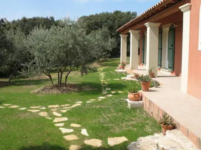 a garden with trees and a walkway next to a house at Ll POULIDETTO in Lioux