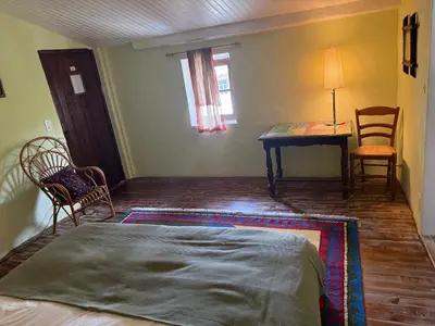 a bedroom with a bed and a table and chairs at Belle de Nuit in Oppède