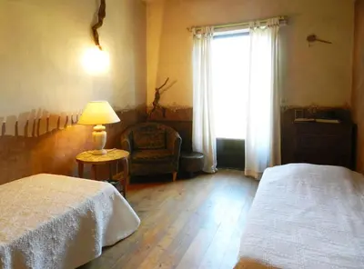 a bedroom with two beds and a lamp and a window at Maison d'artiste in Gargas