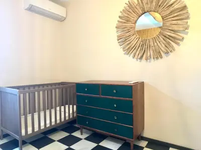 a nursery with a crib and a mirror at Le Mas du Félibre in Caumont-sur-Durance
