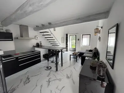 a kitchen and living room with a marble floor at Gîtes dans Mas en pierres in Robion en Luberon