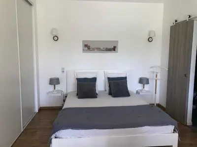 a bedroom with a white bed with two lamps at Gîtes dans Mas en pierres in Robion en Luberon