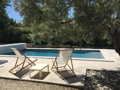 two chairs sitting next to a swimming pool at Villa Louanne in Pertuis