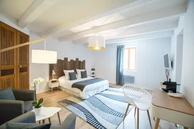 a bedroom with a bed and a living room at La Bastide des Bourguets Adults Only, Mont Ventoux in Sault-de-Vaucluse