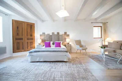 a bedroom with a bed with purple pillows and a couch at La Bastide des Bourguets Adults Only, Mont Ventoux in Sault-de-Vaucluse