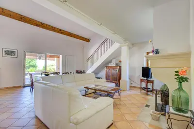 a room with a table and chairs on a balcony at Mas du PERUSSIER in Cucuron