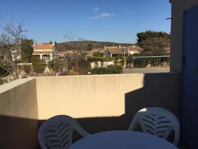 a balcony with a table and a view of a street at Charming rental with shared-pool in the Alpilles. in Mouriès