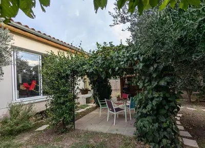 a living room with a leather couch and a large window at La Maison sous l'olivier in Morières-lès-Avignon