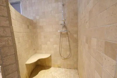 a bathroom with a shower with a bench in it at Nice house with private-pool situated in the heart of the Luberon in Maubec