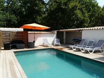 a swimming pool with chairs and an umbrella at Nice house with private-pool situated in the heart of the Luberon in Maubec