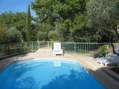 a swimming pool with a white chair and a chair at Spacious villa on two levels in Cabrières-dʼAvignon