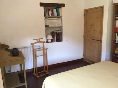 a bedroom with a bed and a shelf with books at 19th century Provencal Mas with pool in Provence in the Luberon, sleeps 6 in Lacoste