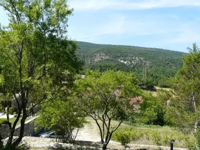 a view of a mountain with trees in the foreground at 19th century Provencal Mas with pool in Provence in the Luberon, sleeps 6 in Lacoste