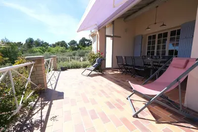 a patio with a pink chair and a table at vacation home with private swimming-pool and a nice view on the luberon mountain, located in merindol, 8 persons in Mérindol